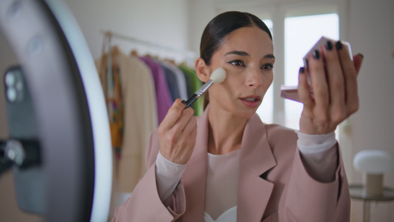 influencer de rostro aplicando polvo grabando blog de belleza. artista de maquillaje hablando