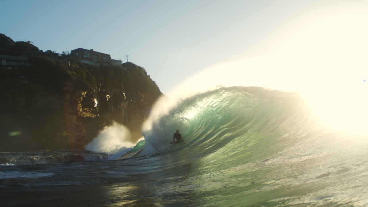 Surfer gets barreled in glowing sunrise light at Whaley Wedge, slow motion with mist and spray