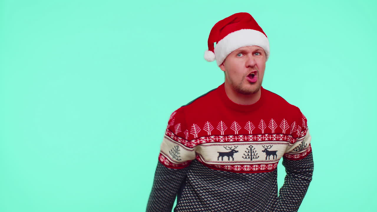 hombre disgustado con suéter de navidad gestando las manos con disgusto, culpando a los regaños por el fracaso