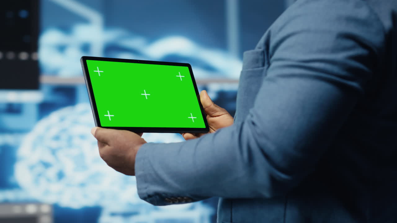 African american coder works on a script with green screen on tablet