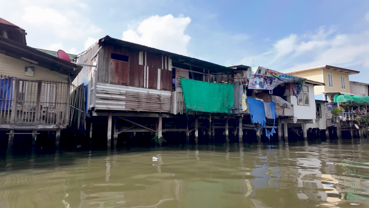 Stilt houses rise above the water, illustrating canal life and urban coastal living