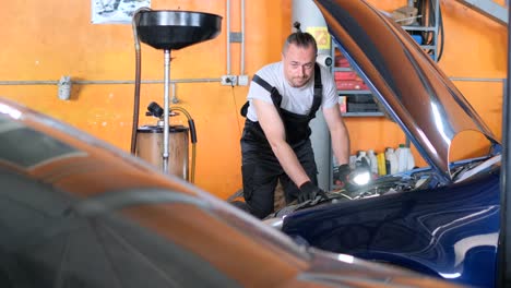 mechanic inspecting car engine in an auto repair shop