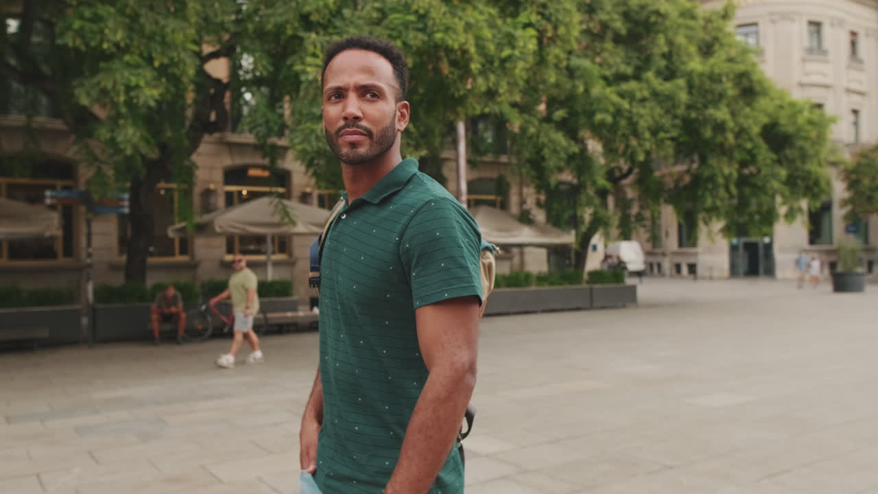 Man in green polo shirt in city setting