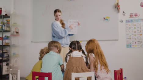 female teacher teaching letters of the alphabet to her pupils in a montessori school 2