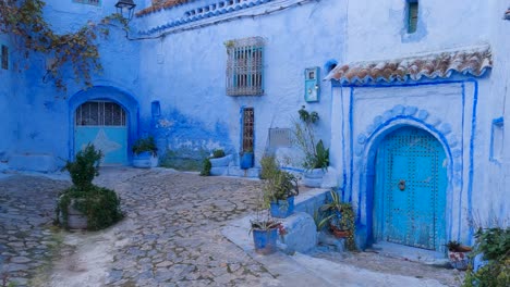 small patio surrounded by blue doors in chefchaouen, morocco - pan