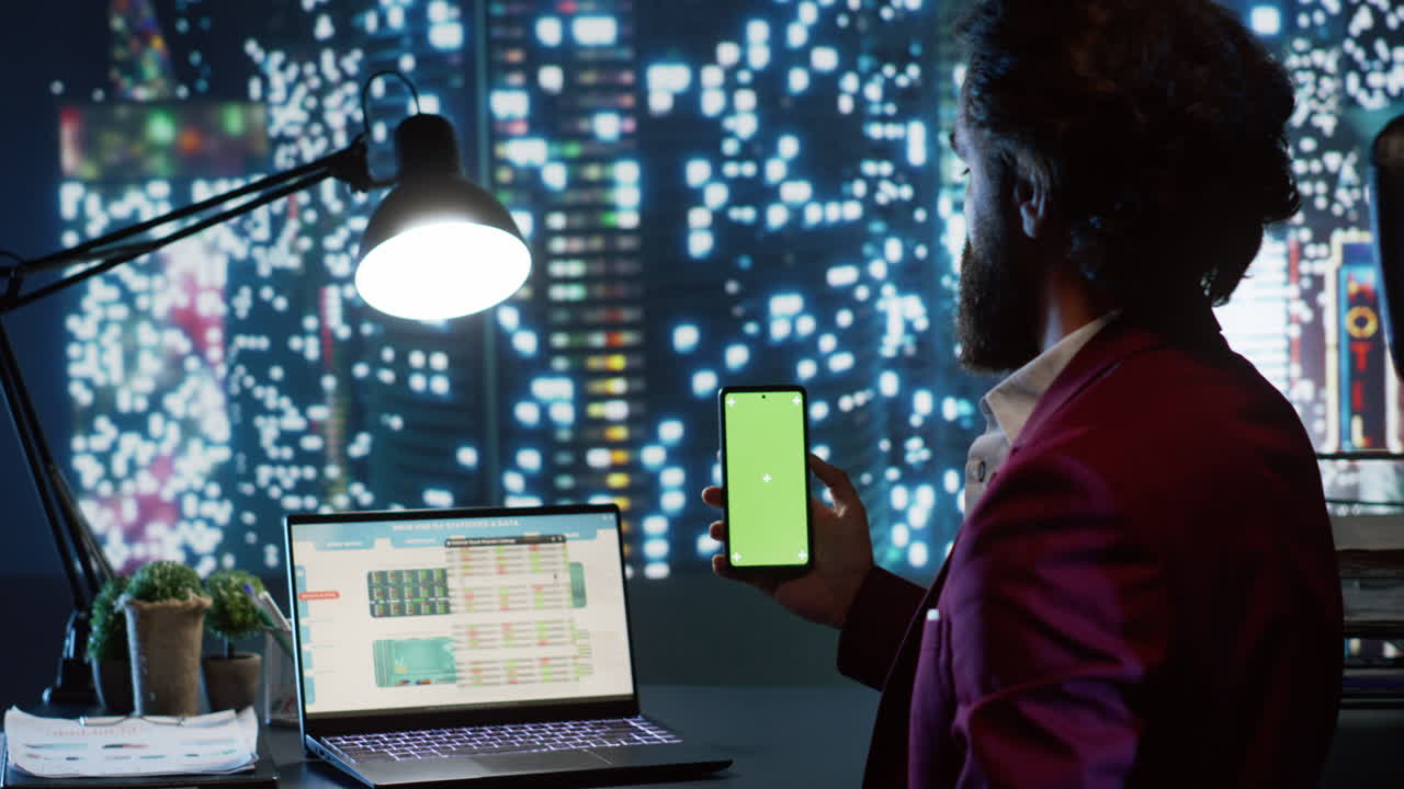 Expert advisor looks at phone with greenscreen display