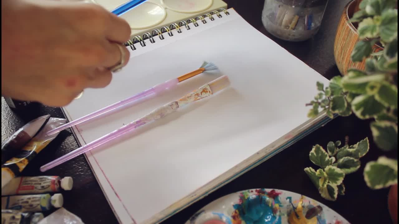 espacio de trabajo de artista con pinceles y cuaderno