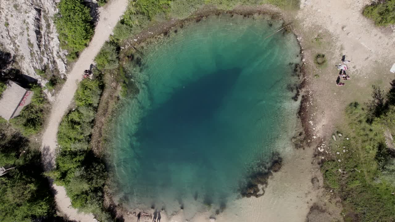 Aerial drone video over Lake Cetina with people walking