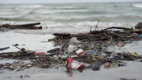 Müll-Und-Müll-Schwimmen-Am-Ufer-Eines-Sehr-Verschmutzten-Und-Schmutzigen-Strandes-Voller-Plastik-Und-Trümmer-Im-Sand-Und-Im-Wasser-Entlang-Der-Küste