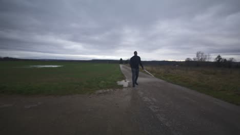 Modern-Black-Swordsman-Warrior-Awaiting-Battle-Opponent-in-Open-Field-Under-Grey-Sky,-Europe,-4K-|-Muscular,-Intimidating,-Shadow,-Figure,-Blurry,-Dark-Clothes,-Powerful,-Out-of-Focus-to-In-Focus-Walk