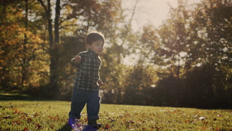 criança asiática feliz corre na grama verde ao sol. infância feliz