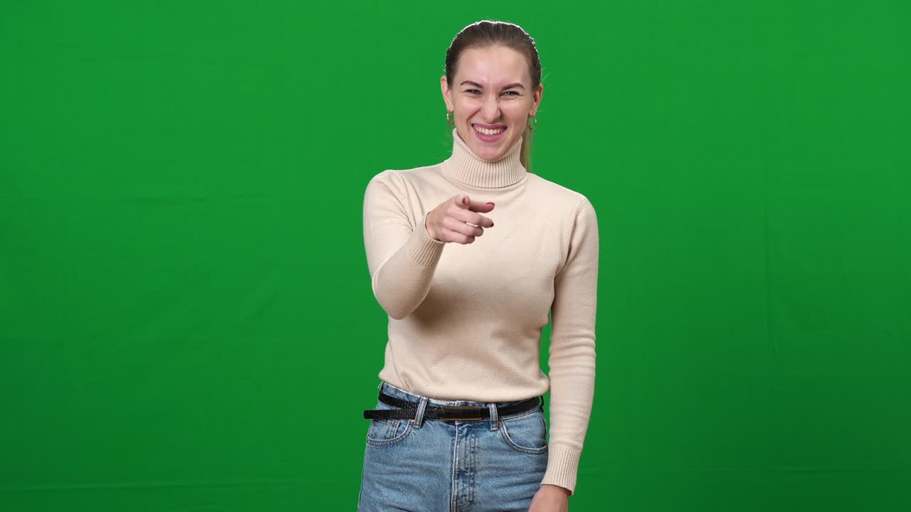 mujer burlándose señalando a la cámara y riendo. retrato de joven grosera delgada dama caucásica burlando en la pantalla verde. intimidación en fondo chromakey