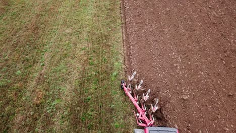 Aerial-view-of-the-plow-being-dragged-behind-a-tractor-to-loosen-the-soil-for-planting-crops