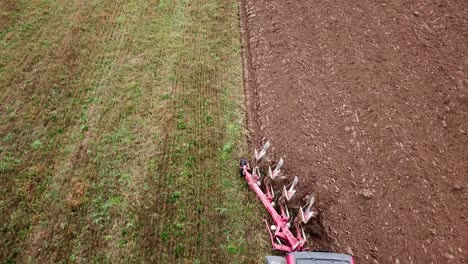 Luftaufnahme-Des-Pfluges,-Der-Hinter-Einem-Traktor-Gezogen-Wird,-Um-Den-Boden-Für-Das-Pflanzen-Von-Pflanzen-Zu-Lockern