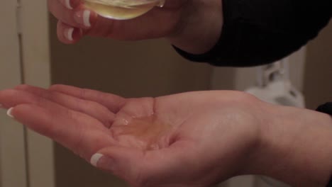 close-up of massage oil being poured into hand.
