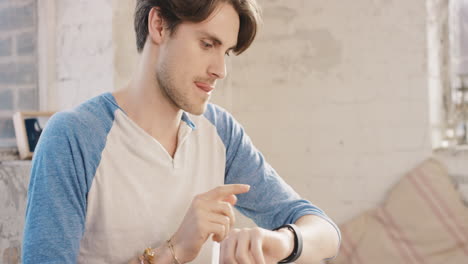 joven estudiante usando reloj inteligente en casa por la mañana bebiendo café
