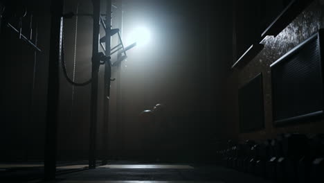 fitness-training-in-gym-at-night-woman-is-playing-with-big-ball-silhouette-shot-in-darkness