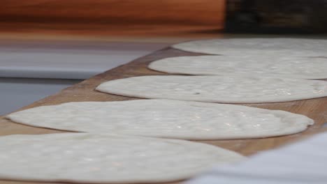 raw pizza dough on a wooden board