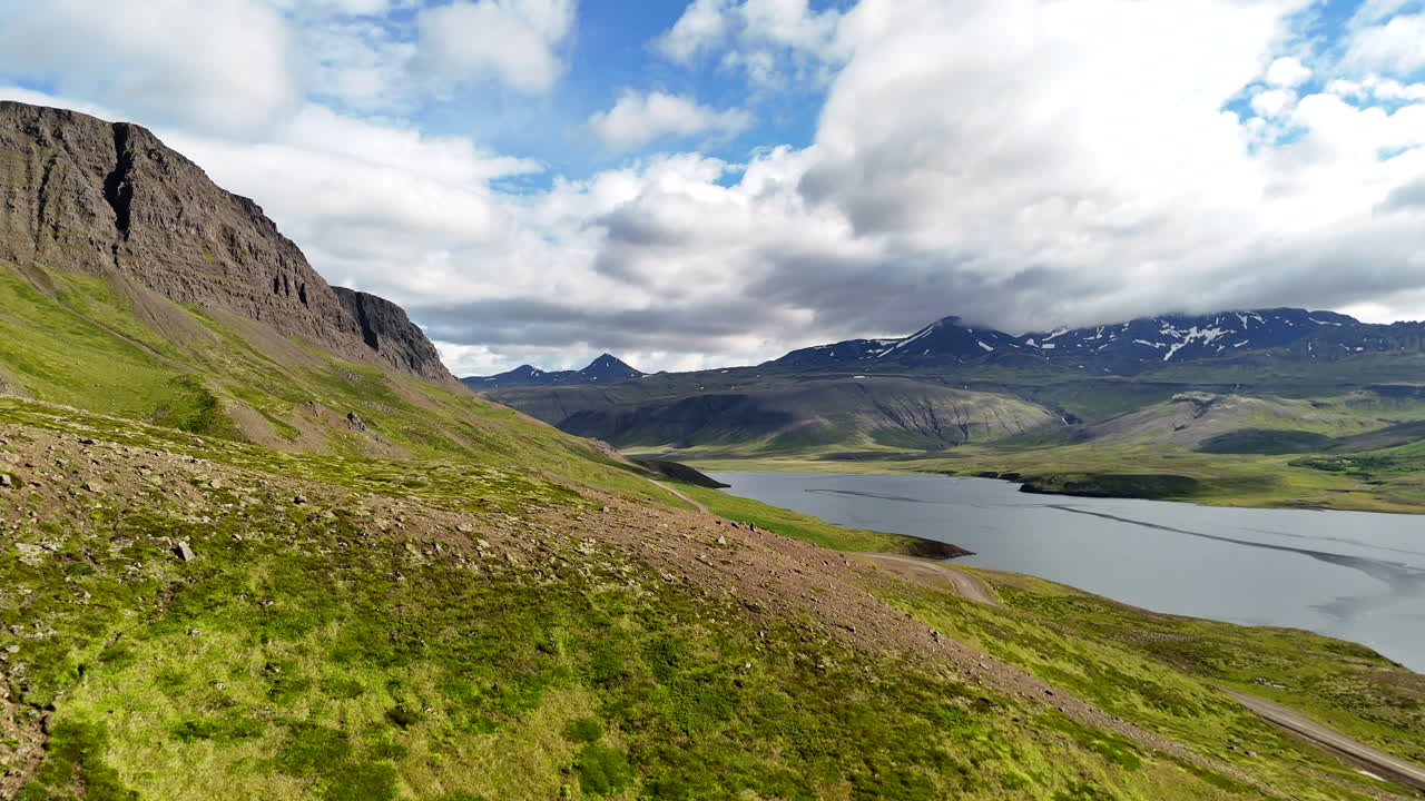 Aerial view of Hvammsfjörður in Vesturland Iceland on a colorful sunny day, showing vibrant waters, surrounding landscape, and clear blue sky from above