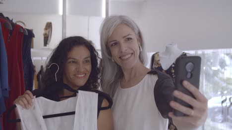 Cheerful-female-friends-enjoying-shopping-together-and-taking-selfie-photo