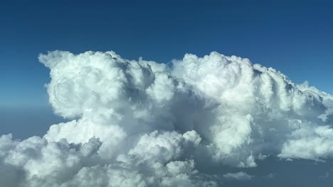 closeup view of a huge storm cloud, cumuloninmbus type, shot from a jet cockpit flying at 12000m high