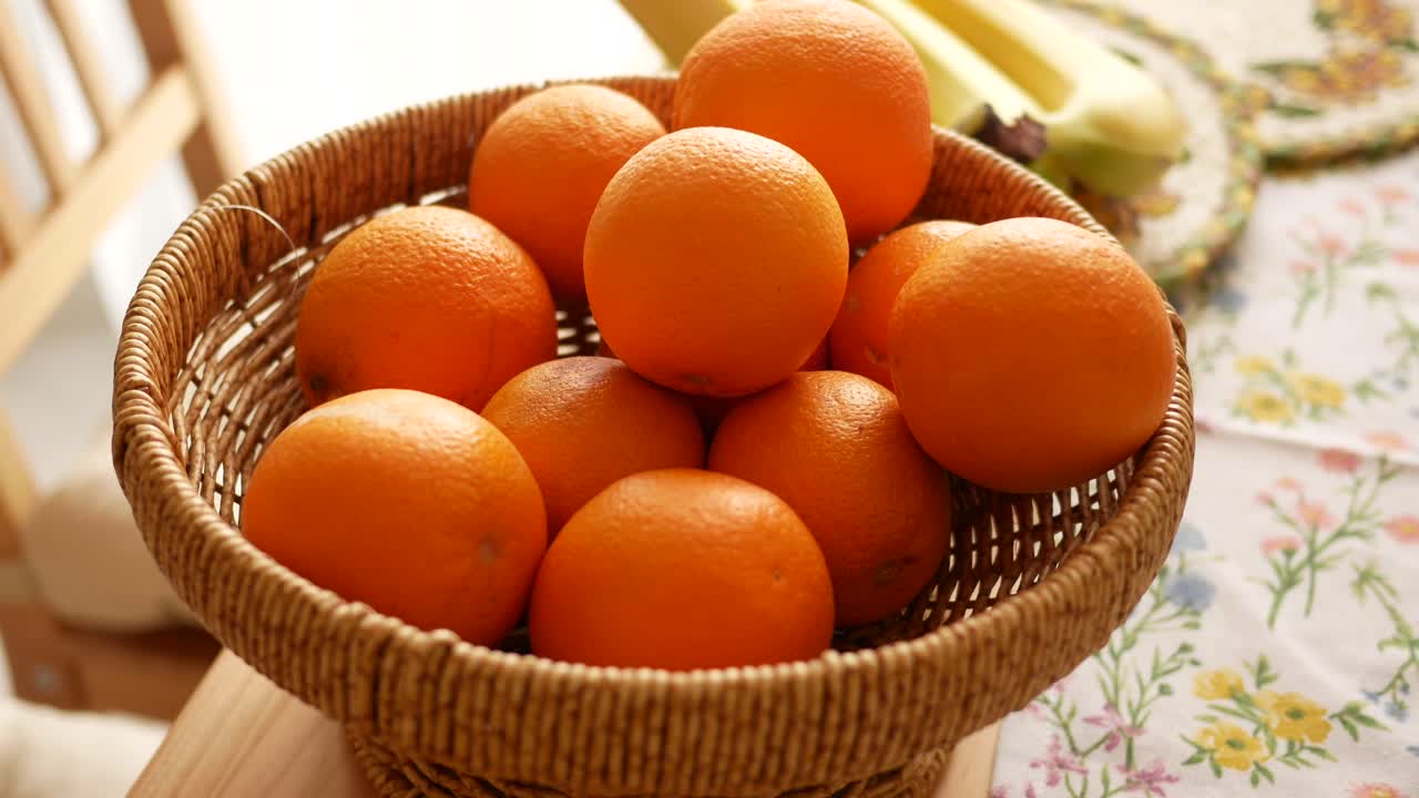 A wicker basket filled with fresh oranges on a table