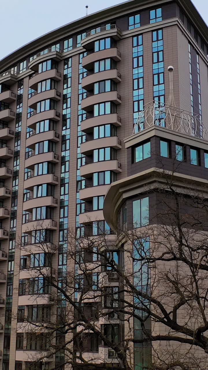 Apartment building room in living area. New block of modern apartments with balconies and blue sky in the background. Vertical video