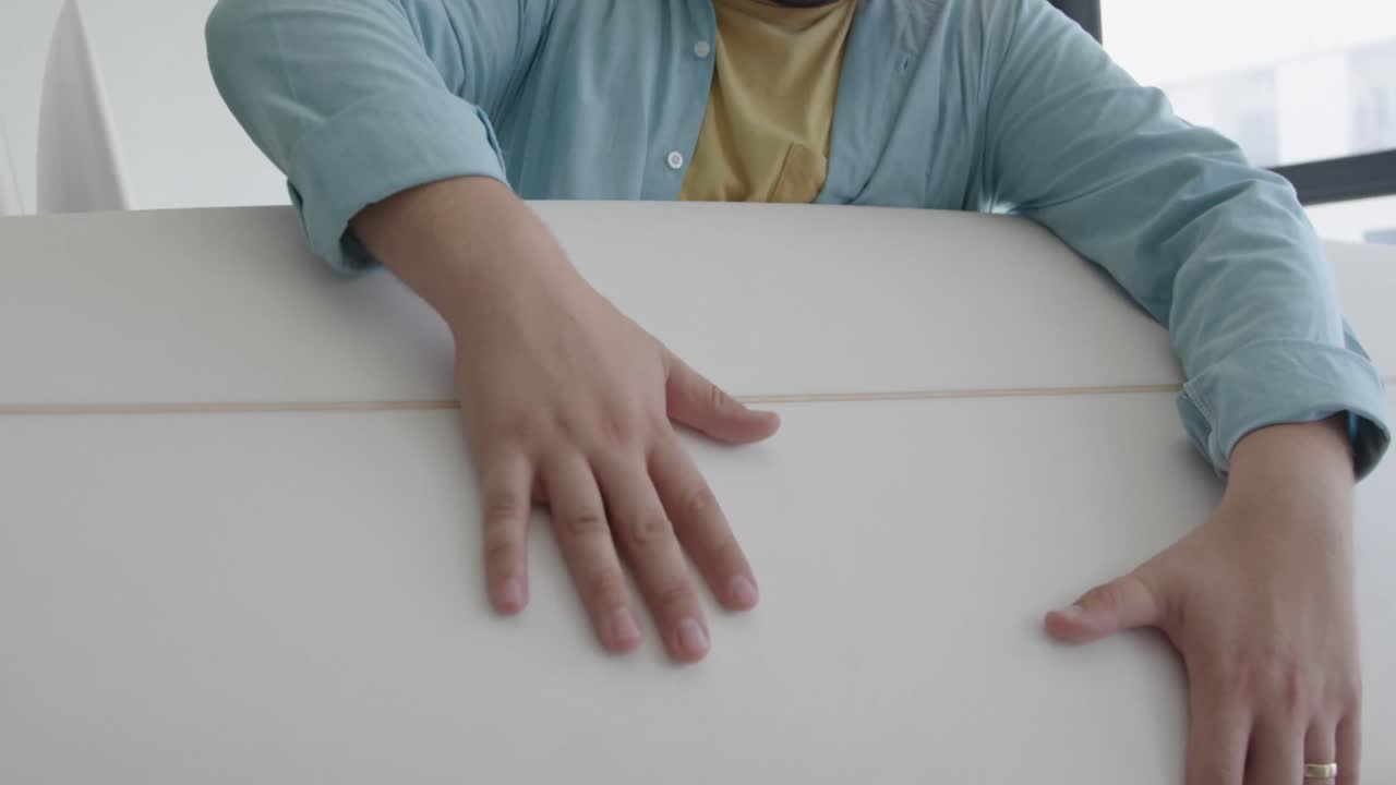 un hombre que hace tablas de surf en su taller