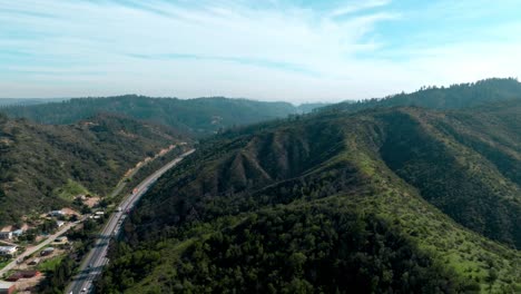 Aerial-view-Asphalt-route-68-Valparaíso-Santiago-surrounded-by-forested-rugged-mountains,-Chile