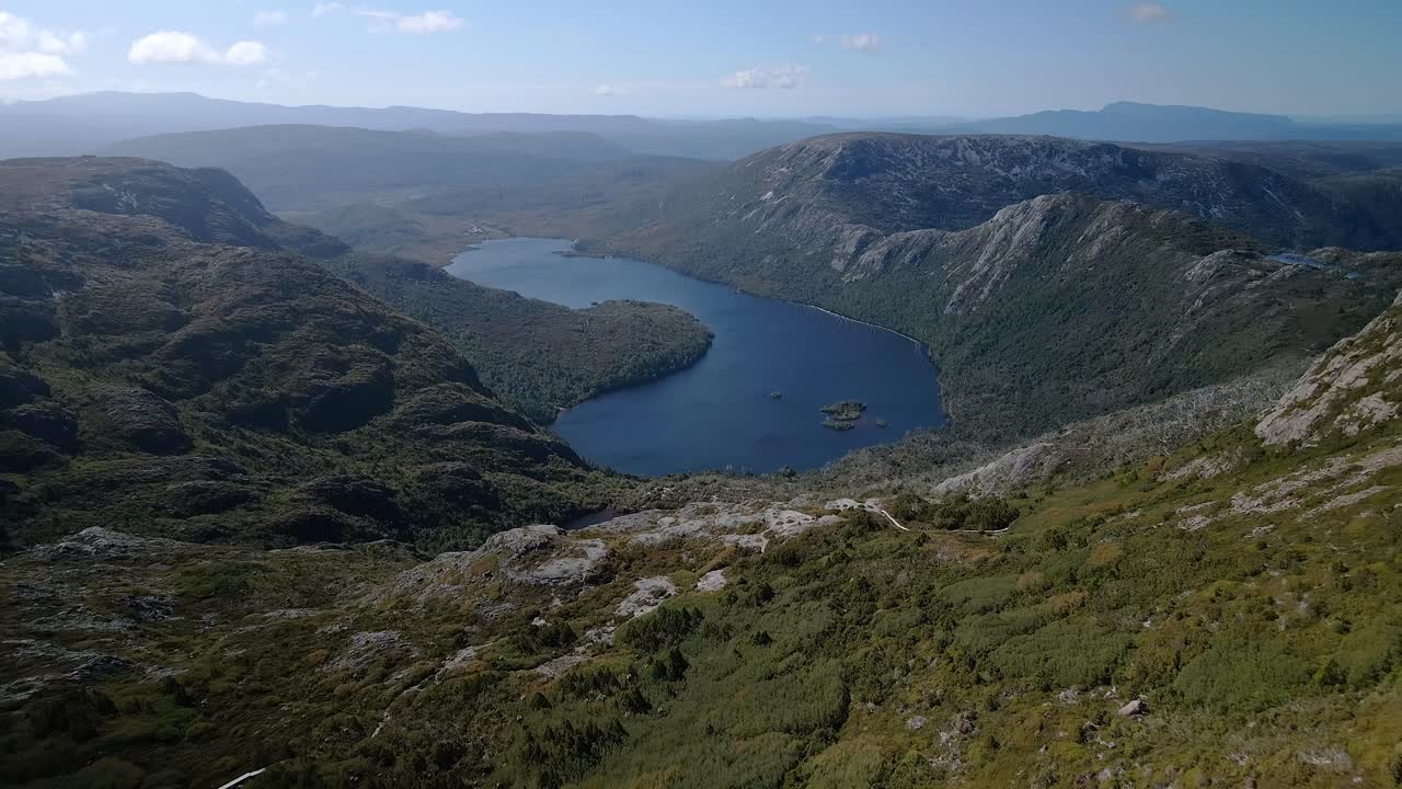 Vista grandangolare di un lago calmo con colline che lo circondano