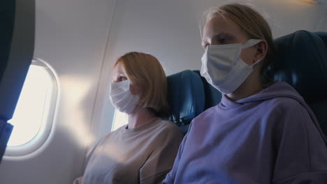 pasajeros de la aeronave con máscaras de protección durante el vuelo. medidas de protección durante la pandemia de covid-19