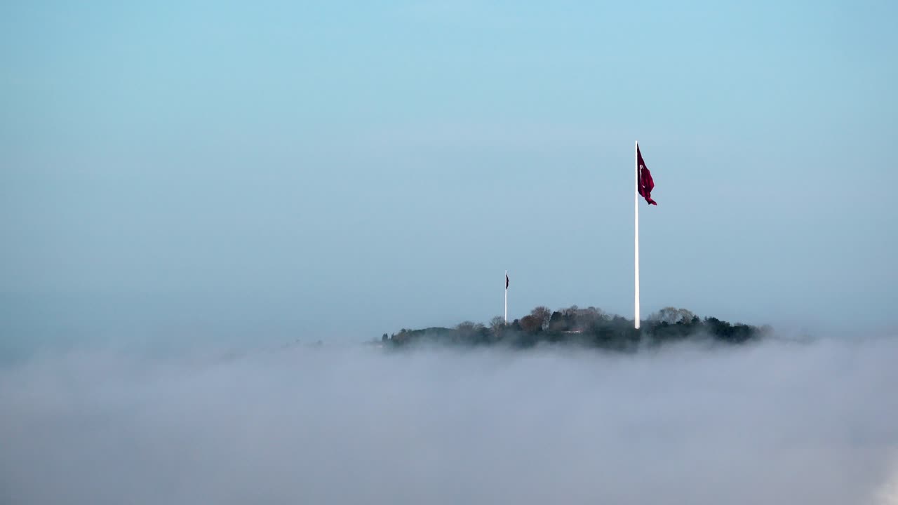 Bandiera turca in cima a una collina, avvolta nella nebbia mattutina