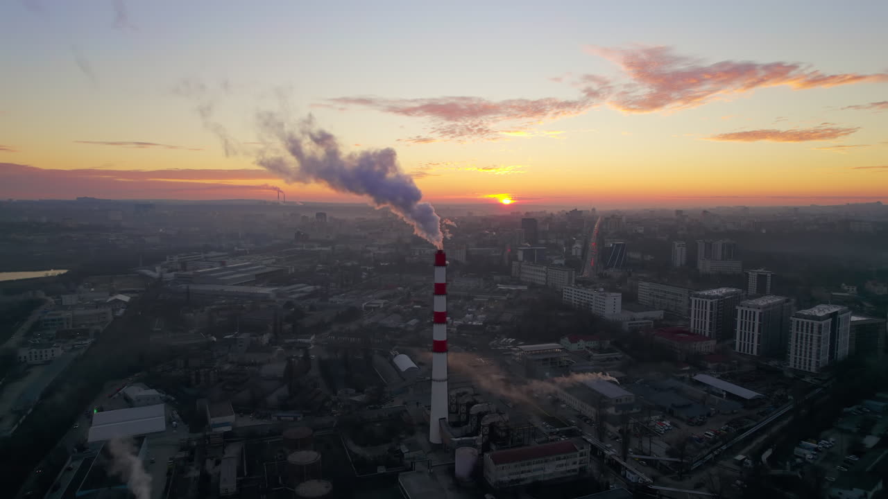 Aerial drone view of thermal power plant in Chisinau at sunrise, Moldova. View of pipe with felling steam, cityscape