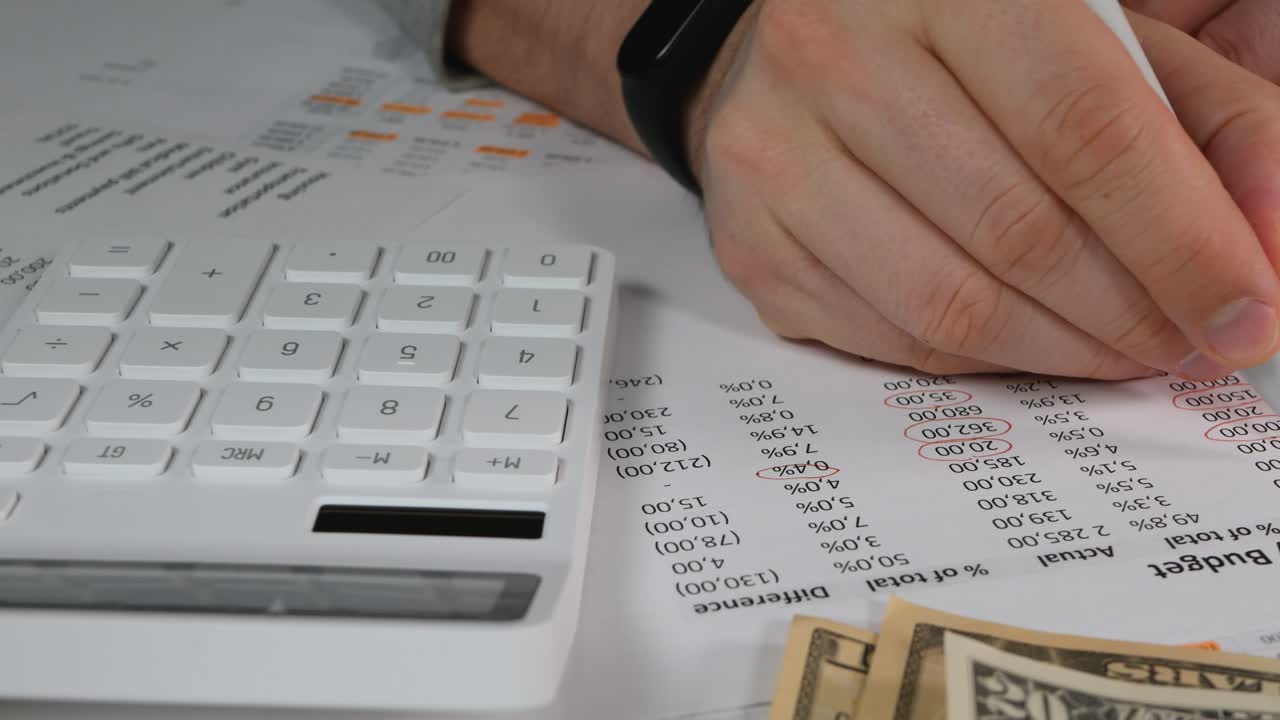 persona irreconocible utiliza una calculadora para administrar el presupuesto mensual personal en el hogar