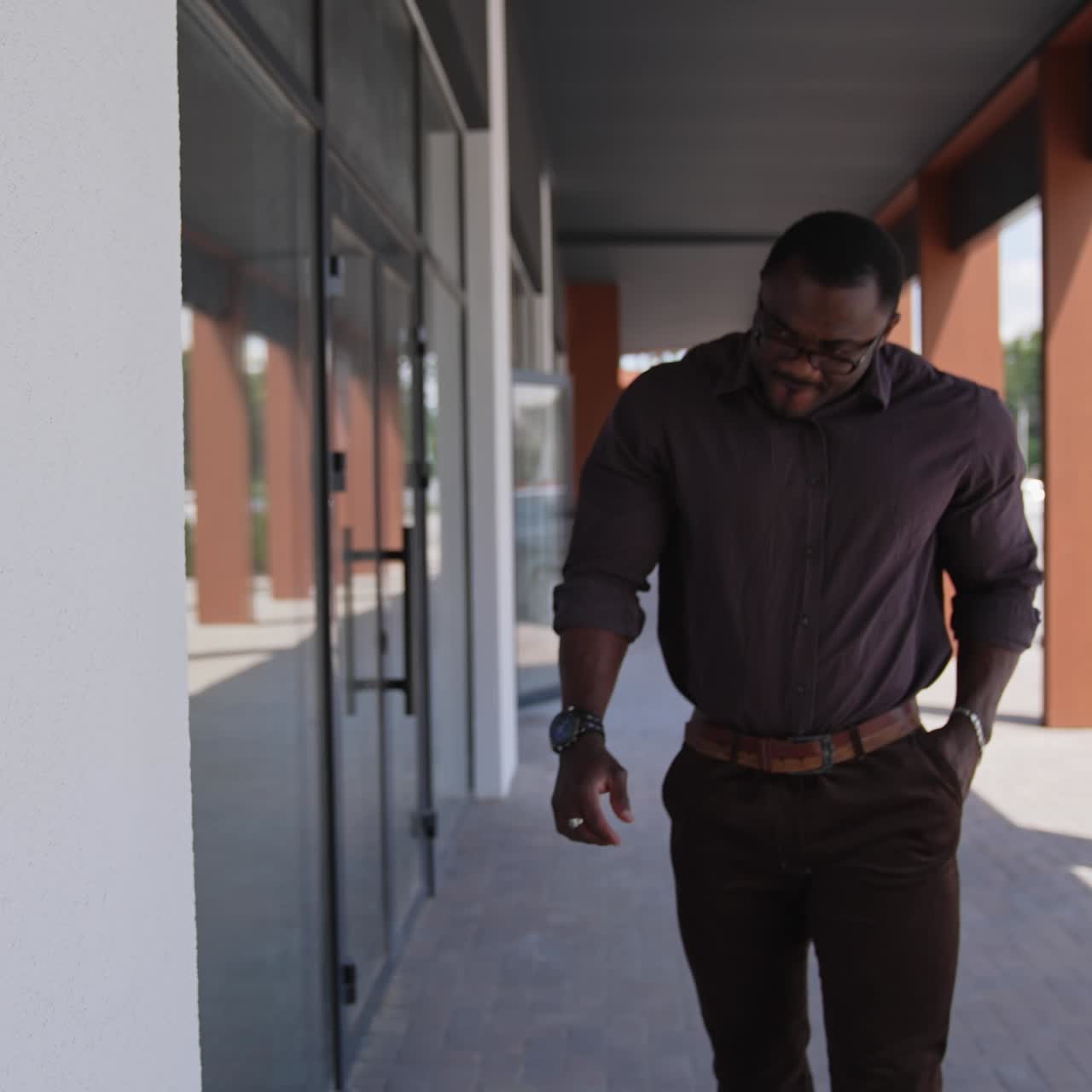 Black man standing in city street. Black man in suit walking on the street in the background