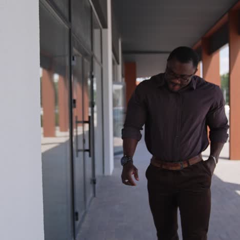 black man standing in city street. black man in suit walking on the street in the background
