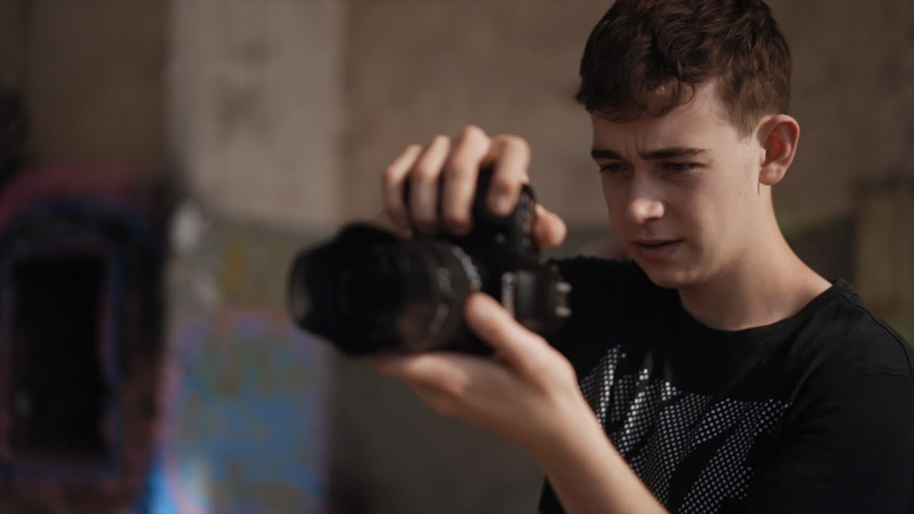 adolescente masculino enfocado tomando fotos con cámara dslr, cámara lenta
