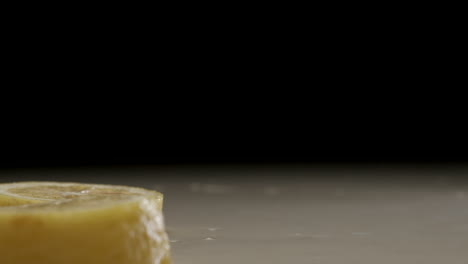 Frisch-Geschnittene-Zitrone-Fällt-Und-Spritzt-In-Zeitlupe-Auf-Wasser