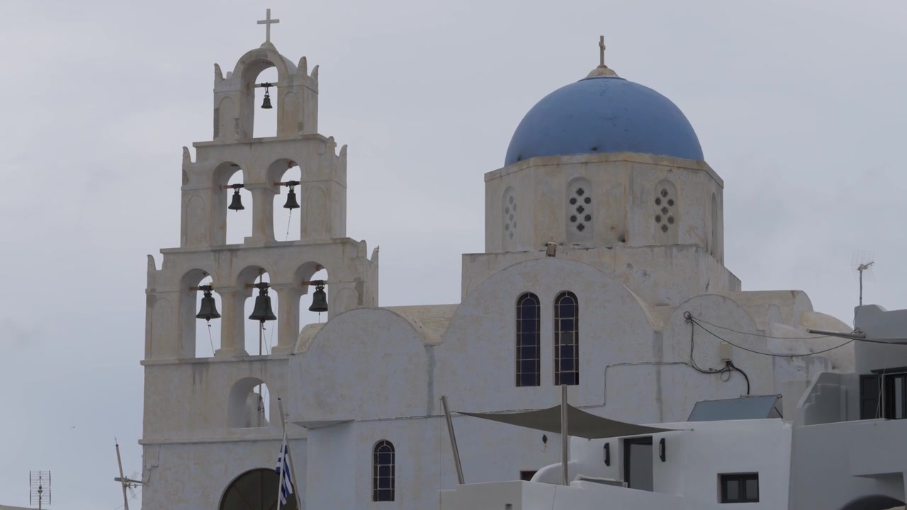 Whitewashed Agia Theodosia church with its blue dome and bell tower in Pyrgos village, Santorini