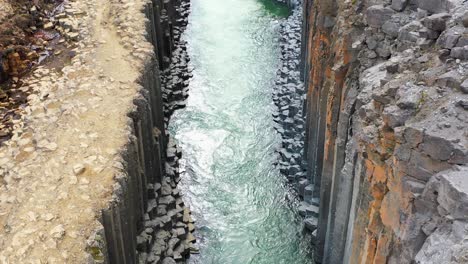 imágenes aéreas ascendentes de columnas de basalto en el cañón de studlagil en el este de islandia