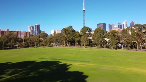 Rise-up-aerial-view-of-construction-tower-crane-in-East-Perth-revealing-city-skyline-in-the-distance