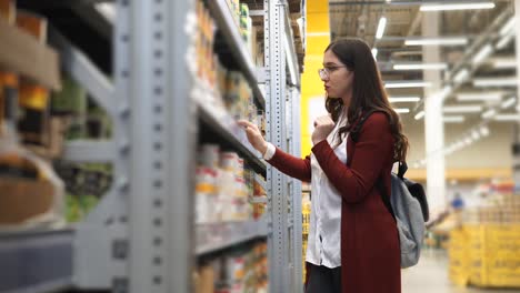 woman shopping for canned goods in a grocery store
