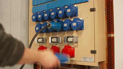panel eléctrico con conectores trifásicos azules 16a y rojos 32a y caja de distribución