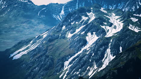 aerial over valley with snow capped mountains in distance