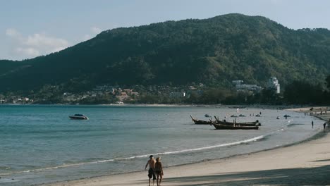 ciudadano de tailandia caminando en la playa de phuket durante un día soleado