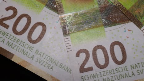 several 200 swiss franc banknotes rotating