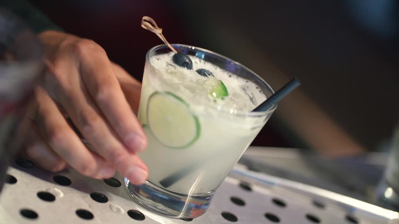 Close-Up Hand Holding a Drink at Nighttime Celebration Event