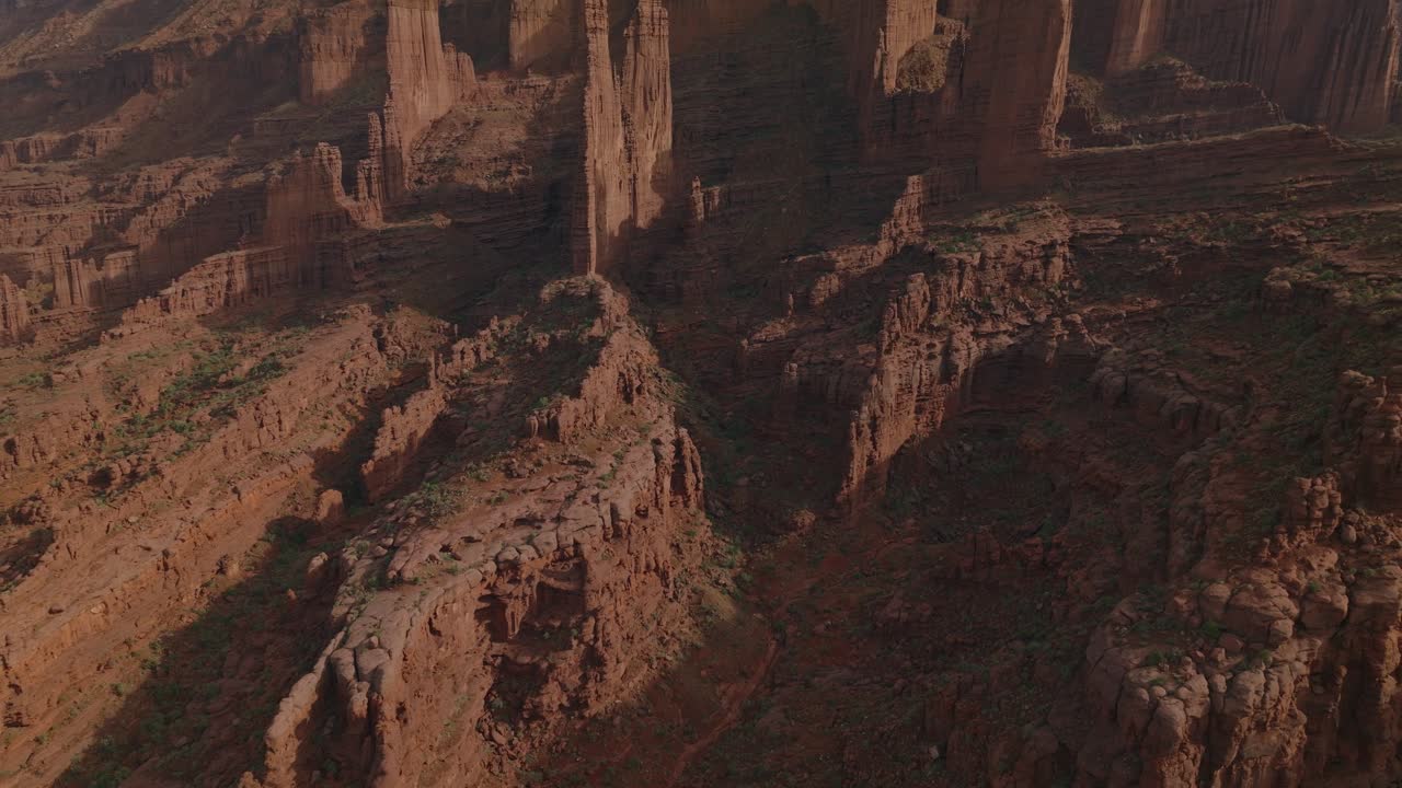 Aerial view of Moab's Fisher Towers at sunrise, showcasing red rocky landscape