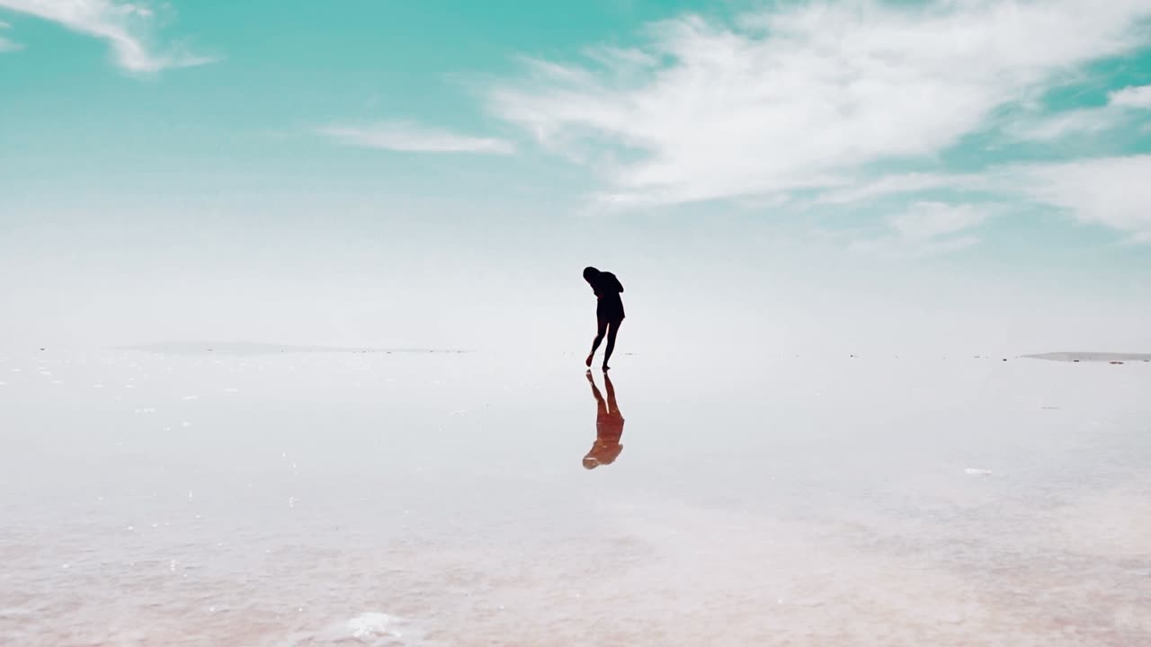 Female person silhouette walking on plain white salt lake field ground . Chromakey person in isolated background