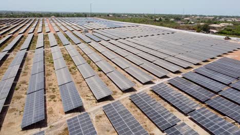 battery energy storage system bess and solar photovoltaic power supply farm - fast sliding aerial view over extensive solar panel arrays